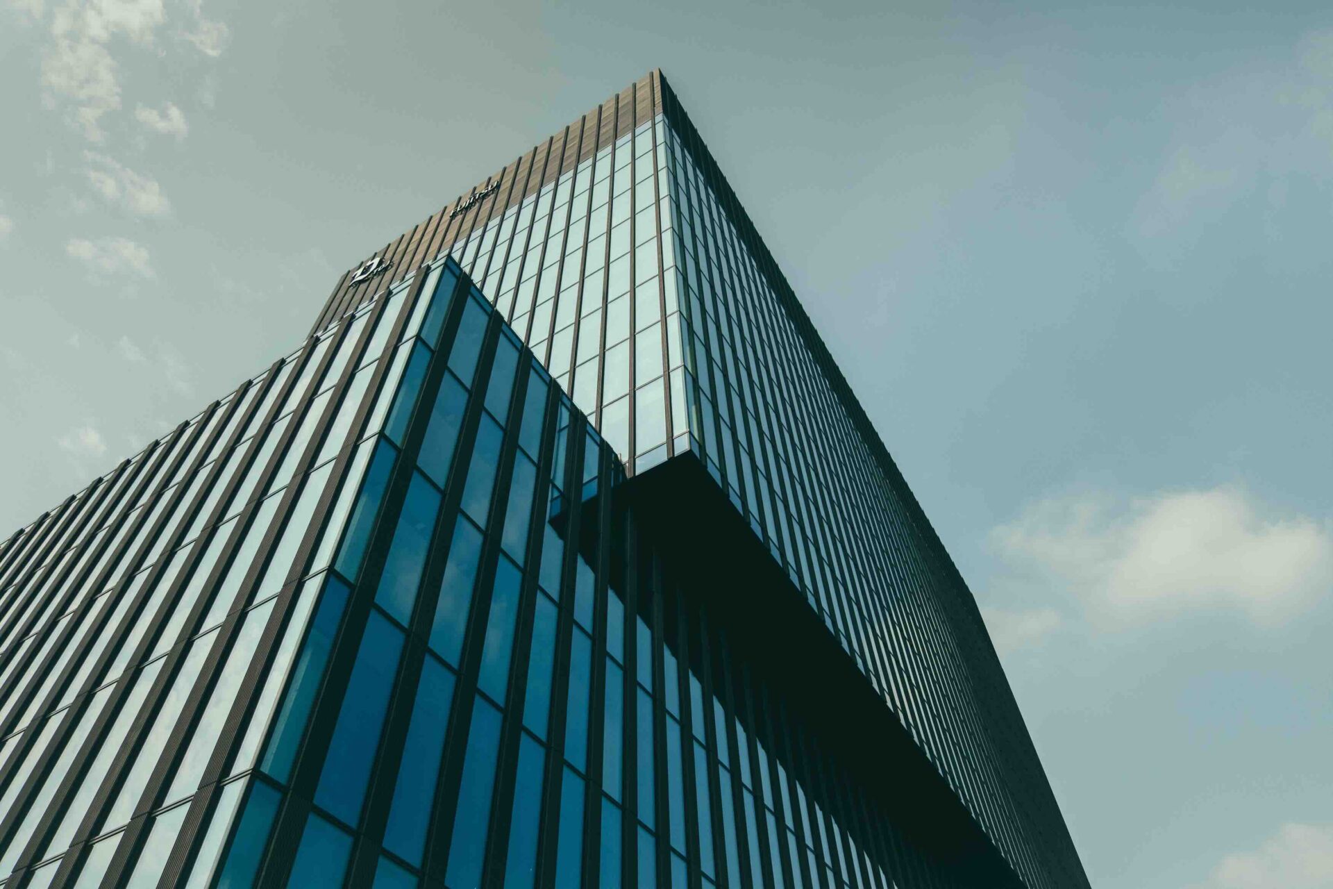 A low angle shot of a building in a glass facade under the beautiful cloudy sky